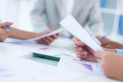 Close-up of human hands holding documents at the business conference