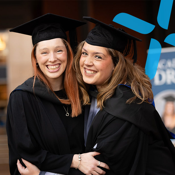 Two smiling girls in graduation uniform